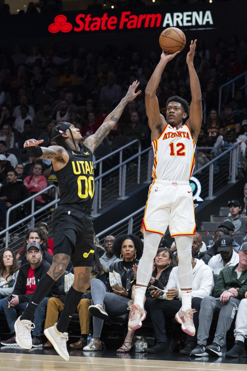 Atlanta Hawks forward De'Andre Hunter (12) shoots a 3-pointer against Utah Jazz guard Jordan Clarkson (00) during the second half of an NBA basketball game Tuesday, Feb. 27, 2024, in Atlanta. (AP Photo/Hakim Wright Sr.)