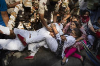 India's opposition Congress party supporters protesting against gang rape and killing of a woman in Uttar Pradesh’s Hathras district hold onto each other as Indian policemen try to detain them in New Delhi, India, Wednesday, Sept. 30, 2020. The gang rape and killing of the woman from the lowest rung of India's caste system has sparked outrage across the country with several politicians and activists demanding justice and protesters rallying on the streets. (AP Photo/Altaf Qadri)