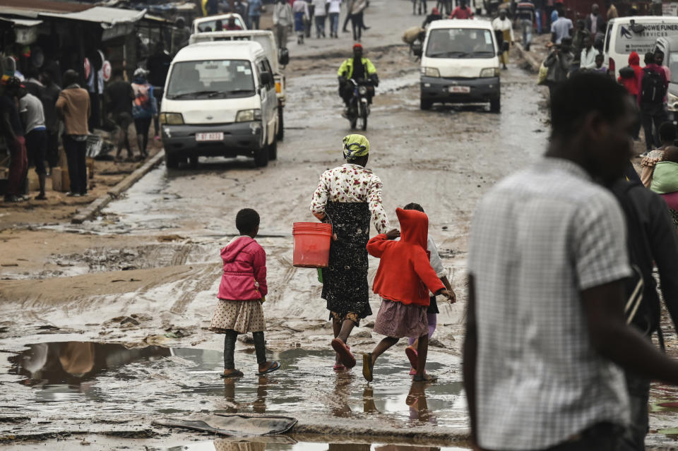 People walk down a flooded street following heavy rains caused by tropical Cyclone Freddy in Blantyre, southern Malawi, Wednesday, March 15, 2023. After barreling through Mozambique and Malawi since late last week and killing hundreds and displacing thousands more, the cyclone is set to move away from land bringing some relief to regions who have been ravaged by torrential rain and powerful winds. (AP Photo/Thoko Chikondi)