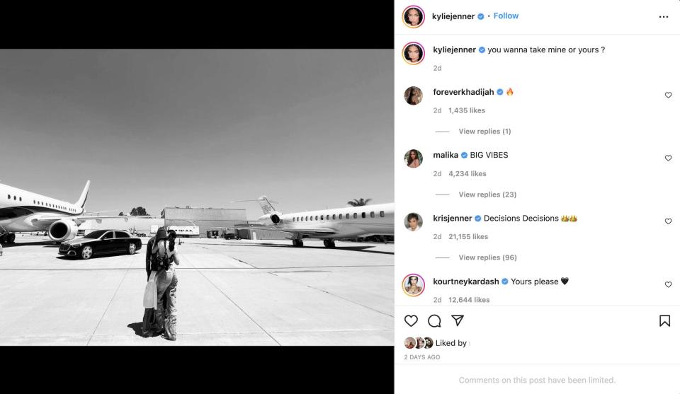 A photo of Travis Scott and Kylie Jenner hugging in front of two private jets.