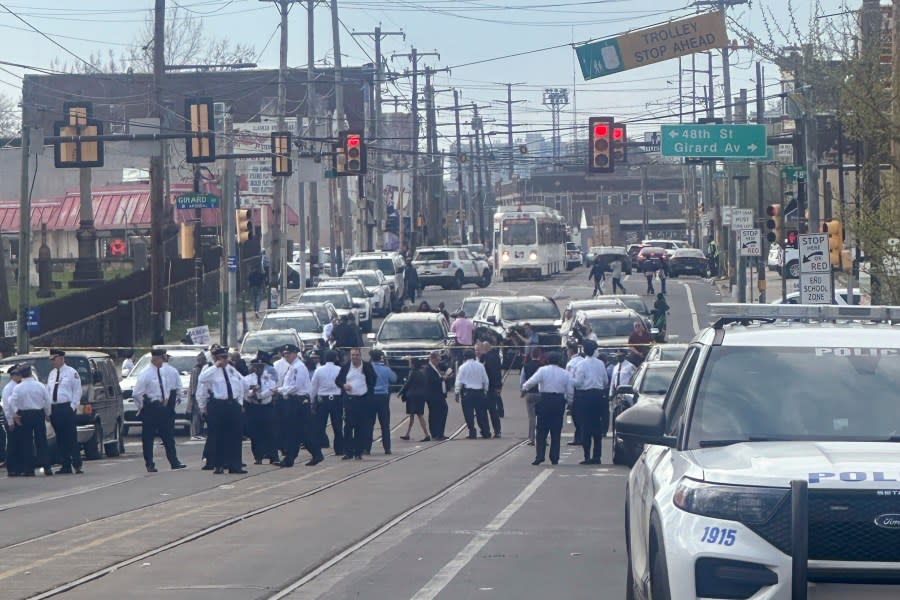 Police and officials gather on a cordoned off street at the scene of a shooting, Wednesday, April 10, 2024, in Philadelphia. (AP Photo/Claudia Lauer)