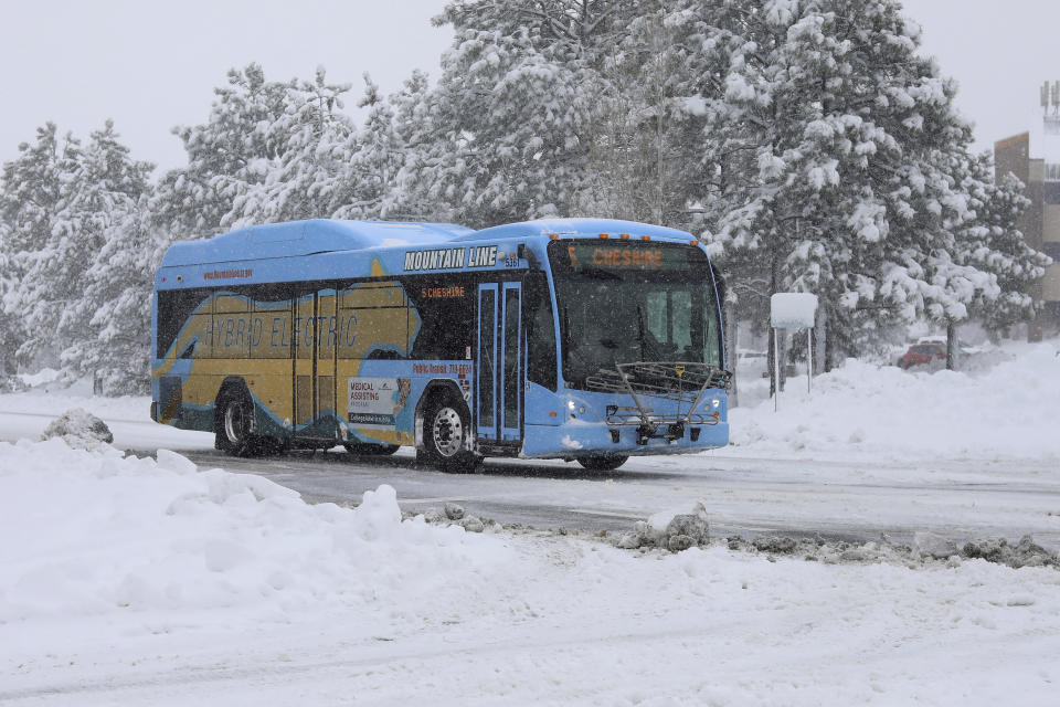 A bus from the Northern Arizona Intergovernmental Public Transportation Authority (NAIPTA) turns toward downtowndowntown Flagstaff, Ariz., Friday, Nov. 29, 2019. A powerful storm making its way east from California is threatening major disruptions during the year's busiest travel weekend, as forecasters warned that intensifying snow and ice could thwart millions across the country hoping to get home after Thanksgiving. . (Cody Bashore/Arizona Daily Sun via AP)
