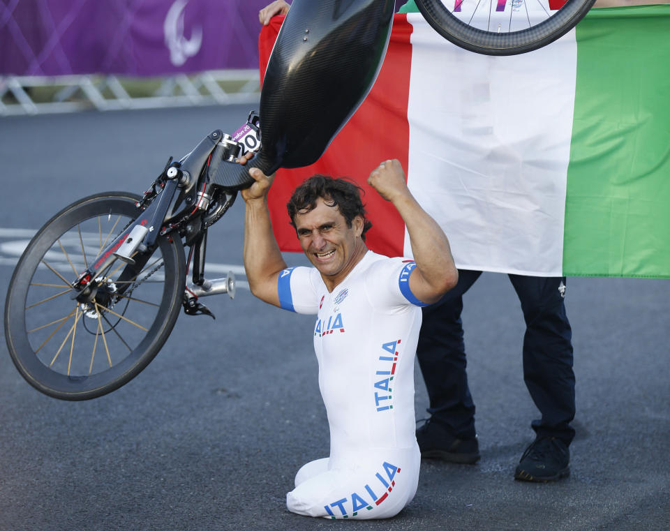 Italy's Alessandro Zanardi lifts his hand-cycle after winning the Men's Individual H4 - Road Race during the London 2012 Paralympic Games, at Brands Hatch racing track in southeast England September 7, 2012. In the H4 class category, athletes have impairments to their legs and race using a hand-cycle. REUTERS/Luke MacGregor (BRITAIN - Tags: SPORT CYCLING OLYMPICS)