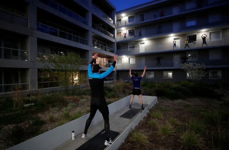 Residents exercise on their balconies following fitness trainers in Nantes