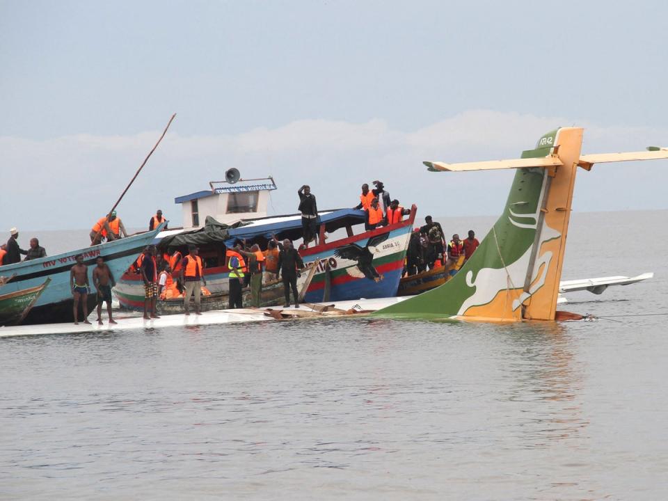 Passengers are taken to safety from the jet in the lake (AFP/Getty)