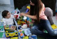 Emmanuelle Lteif Khnaisser, who was in labour at the moment of last year's Beirut port blast, plays with her son baby George Khnaisser, at the family home in Jal el-Dib