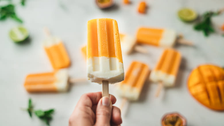 Person holding a popsicle with other popsicles in the background