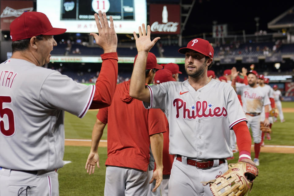 Philadelphia Phillies' Matt Vierling, right, high-fives bench coach Mike Calitri as he walks off the field after the second game of a baseball doubleheader against the Washington Nationals, Friday, June 17, 2022, in Washington. Philadelphia won 8-7 in 10 innings. (AP Photo/Patrick Semansky)