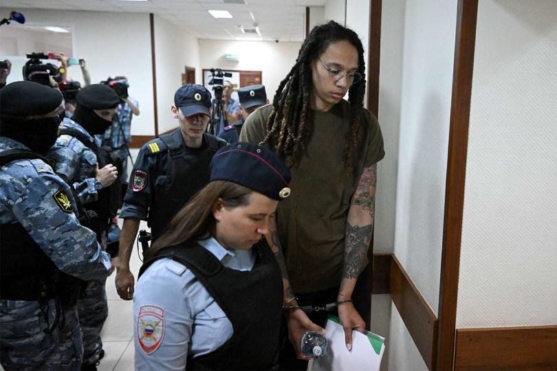 US basketball player Brittney Griner (R) is escorted by police before a hearing during her trial on charges of drug smuggling, in Khimki, outside Moscow on August 2, 2022. - Griner was detained at Moscow's Sheremetyevo airport in February 2022 just days before Moscow launched its offensive in Ukraine. She was charged with drug smuggling for possessing vape cartridges with cannabis oil. Speaking at the trial on July 27, Griner said she still did not know how the cartridges ended up in her bag. (Photo by Natalia