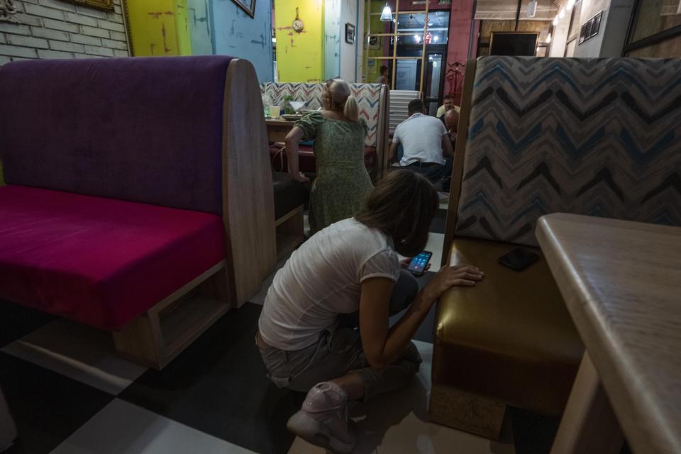 People take cover on the floor during a strike in Kramatorsk, Donetsk region, eastern Ukraine, Thursday, July 7, 2022. (AP Photo/Nariman El-Mofty)