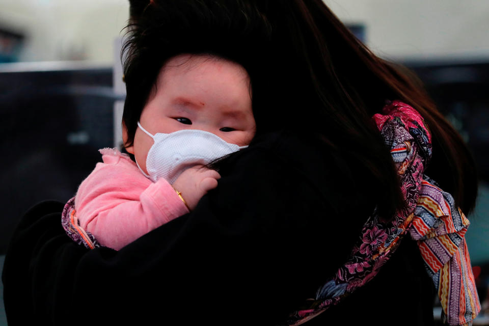 A child wears a mask to prevent an outbreak of a new coronavirus at the Hong Kong West Kowloon High Speed Train Station, in Hong Kong, China January 23, 2020. REUTERS/Tyrone Siu