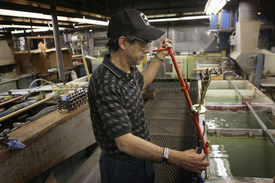 CHICAGO, IL - FEBRUARY 09: Manuel Nunez demonstrates the plating process for an Oscar statuette at R.S. Owens & Company February 9, 2012 in Chicago, Illinois. R.S. Owens manufactures the Oscar statuettes which are presented at the annual Academy Awards by the Academy of Motion Picture Arts and Sciences. After the theft of the statuettes prior to the 2000 Academy Awards the company began casting the statuettes one year in advance of the show. (Photo by Scott Olson/Getty Images)