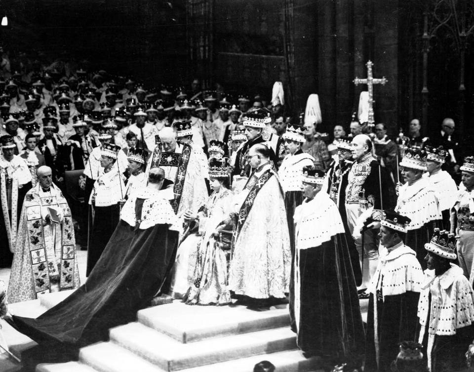 Britain’s Prince Philip, the Duke of Edinburgh, kneeling, places his hands between those of Queen Elizabeth II, his wife, as he swears homage, during the coronation ceremony in Westminster Abbey, June 2, 1953. | Associated Press