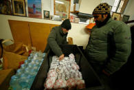 A volunteer distributes cheeseburgers donated by McDonald's to a charity organization which bestowed them to needy people at a walk-in clinic in Rome, Italy January 16, 2017. REUTERS/Tony Gentile