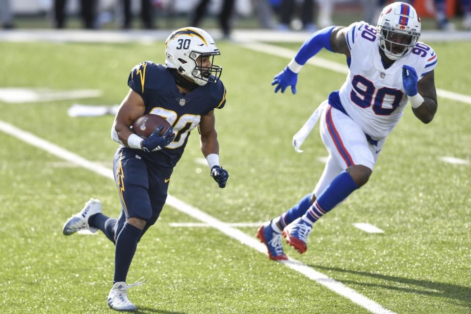 Chargers running back Austin Ekeler runs ahead of Buffalo Bills defensive tackle Quinton Jefferson.