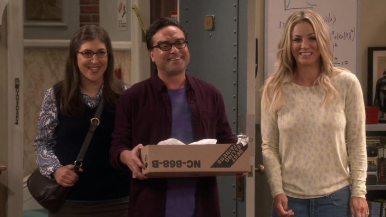  Amy, Leonard and Penny smiling in Sheldon's apartment on The Big Bang Theory. 
