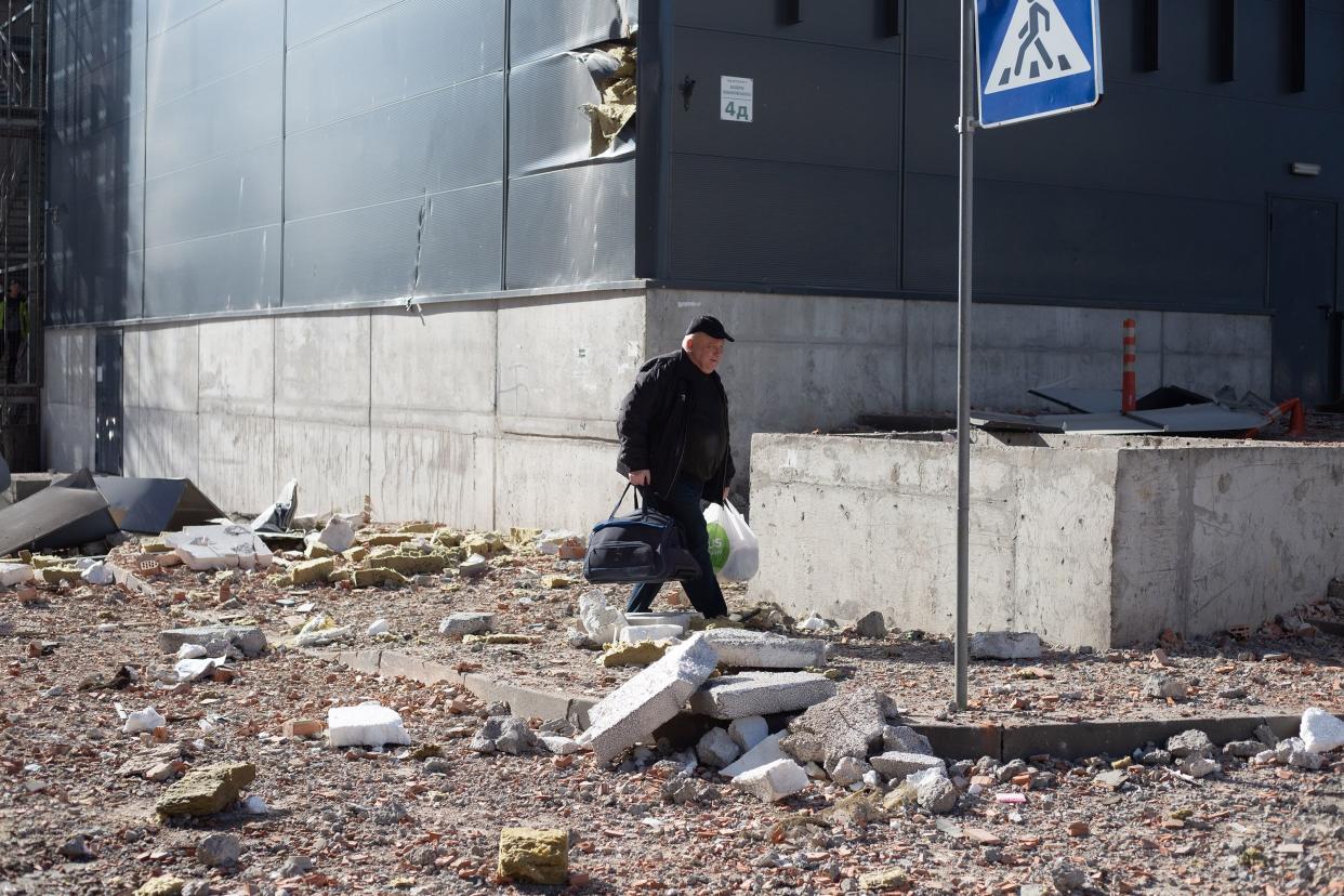 Residents leave the apartment block in 6A Lobanovsky Ave. which was hit with a missile on Feb. 26, 2022, in Kyiv, Ukraine.