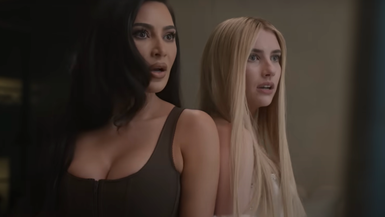 kim kardashian and emma roberts standing shoulder to shoulder with shocked expressions on their faces in a scene for american horror story delicate
