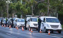 Police check drivers at a roadblock in suburban Melbourne, Australia, Thursday, July 2, 2020. Thousands of residents in dozens of suburbs of Melbourne, are preparing to lockdown for a month with the Victoria state premier warning a state-wide shutdown is possible if coronavirus cases continue to rise. (Daniel Pockett/AAP Image via AP)