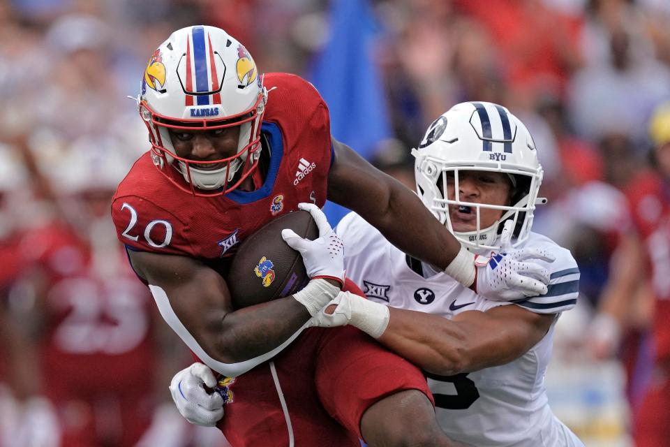 Kansas running back Daniel Hishaw Jr. (20) is tackled by BYU linebacker Ace Kaufusi during the second half of a game Sept. 23 this year in Lawrence. Kansas won 38-27.