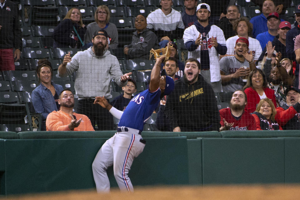 Texas Rangers' Ezequiel Duran waits to catch a pop foul by Cleveland Guardians' Andres Gimenez as a spectator tries to distract him during the sixth inning of the second game of a baseball doubleheader in Cleveland, Tuesday, June 7, 2022. (AP Photo/Phil Long)