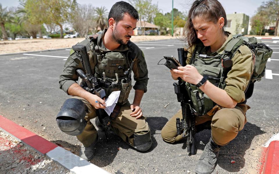 Israeli soldiers inspecting some of the debris following the missile launch - AHMAD GHARABLI/AHMAD GHARABLI