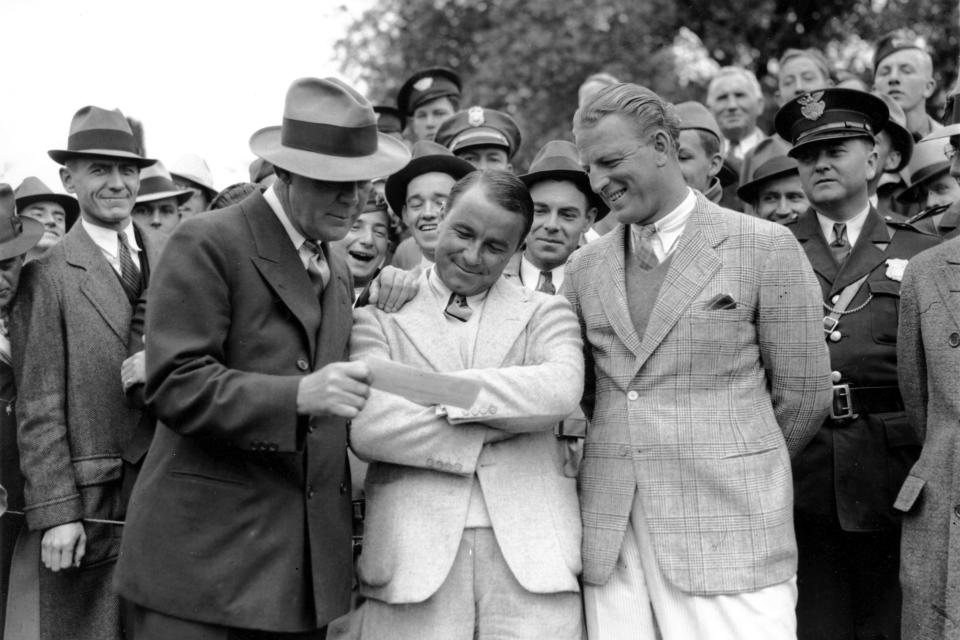 FILE - In this April 8, 1935, file photo, golfer Gene Sarazen, center, receives a check for $1,500 from sportswriter Grantland Rice, left, for winning the Augusta National Invitation Tournament in Augusta, Ga. Sarazen beat Craig Wood, right, to win the tournament. The Masters wasn't even the Masters in 1935. It was the Augusta National Invitation Tournament, the second edition. Craig Wood was the presumed winner, in the clubhouse at 282, until one shot changed everything. (AP Photo/File)