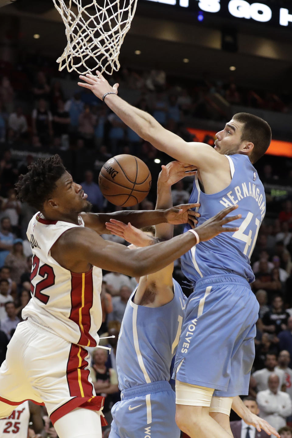 Miami Heat forward Jimmy Butler (22) goes up for a shot against Minnesota Timberwolves forwards Juancho Hernangomez (41) and Jake Layman, center, during the second half of an NBA basketball game, Wednesday, Feb. 26, 2020, in Miami. (AP Photo/Wilfredo Lee)