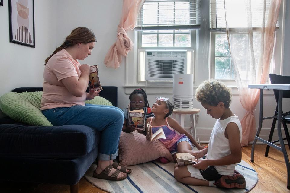 Tutor Erin Letourneau, left, reads to Wynter Whitfield, 8, center left, Caitlyn Heard, 8, center, and Isaiah Cunningham, 8, at Brilliant Detroit in Detroit on Thursday, August 10, 2023.