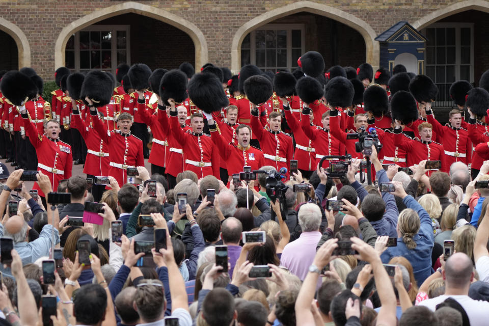 FILE - Members of the public gather as military personnel in ceremonial uniform offer three cheers to the new King at St James's Palace in London, Saturday, Sept. 10, 2022 after King Charles III was proclaimed at the Accession Council. Britain’s royal family turns the page on a new chapter with the coronation of King Charles III. Charles ascended the throne when his mother, Queen Elizabeth II, died last year. But the coronation Saturday is a religious ceremony that provides a more formal confirmation of his role as head of state and titular head of the Church of England. (AP Photo/Kirsty Wigglesworth, Pool, File)