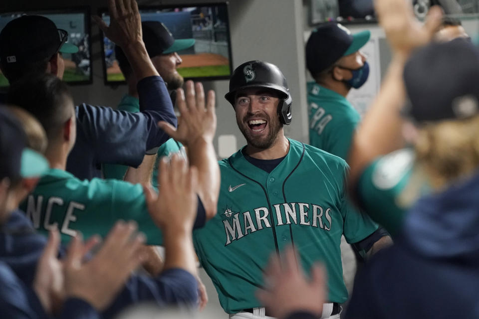 Seattle Mariners' Tom Murphy reacts in the dugout after hitting a two-run home run to also score Luis Torrens during the second inning of a baseball game against the Arizona Diamondbacks, Friday, Sept. 10, 2021, in Seattle. (AP Photo/Ted S. Warren)