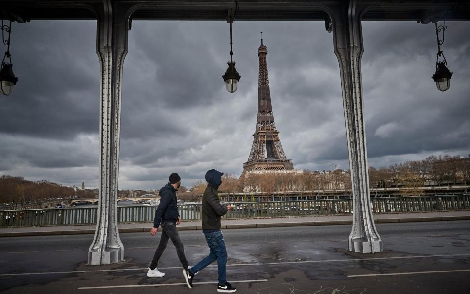 Parisians walk across the river Seine in front of the Eiffel Tower -  Kiran Ridley/ Getty Images Europe