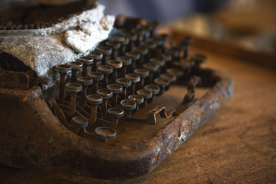 In this June 28, 2019 photo a burned typewriter that belonged to the father of Lali Mitchell is displayed in her home in Harmony Grove, Calif. Mitchell's home where she had lived since moving to the area in 1976, was destroyed in the 2014 Cocos Fire. She said the fire destroyed tens of thousands of dollars worth of art, as well as family mementos, such as her father's typewriter. She escaped the fire by way of the neighborhood's single road. A recently approved housing project along Mitchell's only escape route could put more than 400 additional cars on the road during an evacuation. If it's built, Mitchell said, staying won't be an option. (Kailey Broussard/News21 via AP)