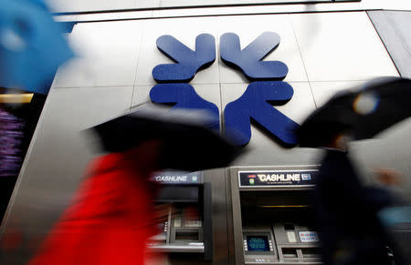 FILE PHOTO: Morning commuters rush past a branch of the Royal Bank of Scotland (RBS) in London November 4, 2011. REUTERS/Andrew Winning/File Photo