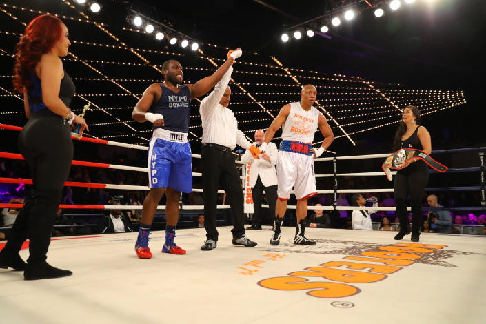 <p>Emmanuel Etienne’s (red) arm is raised after hearing the decison from the judges after he and David Thompson (blue) battled in the ring during a Heavyweight bout in the NYPD Boxing Championships at the Hulu Theater at Madison Square Garden on March 15, 2018. (Gordon Donovan/Yahoo News) </p>