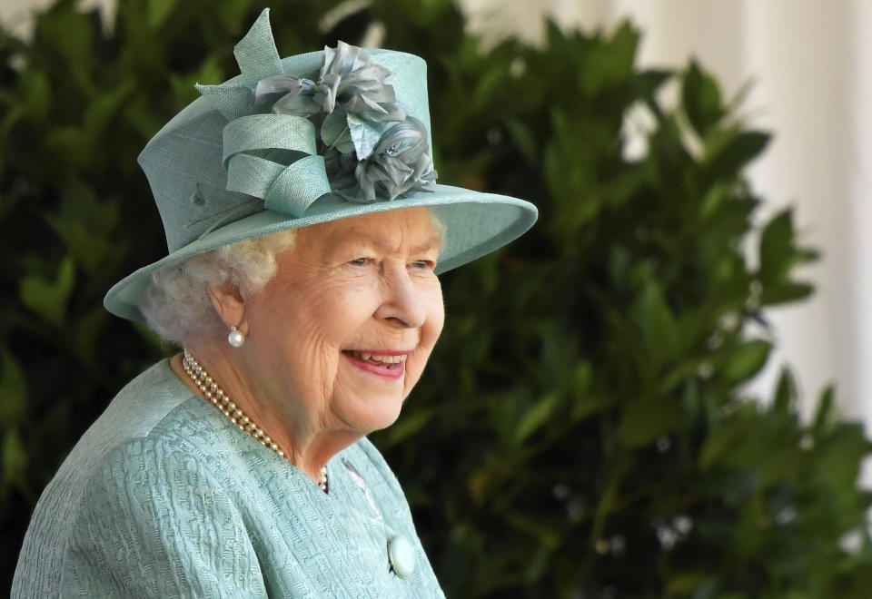 Britain's Queen Elizabeth II reacts as she looks out during a ceremony to mark her official birthday at Windsor Castle in Windsor, England, Saturday June 13, 2020. Queen Elizabeth II’s birthday is being marked with a smaller ceremony than usual this year, as the annual Trooping the Color parade is canceled amid the coronavirus pandemic. The Queen celebrates her 94th birthday this year. (Toby Melville/Pool via AP)