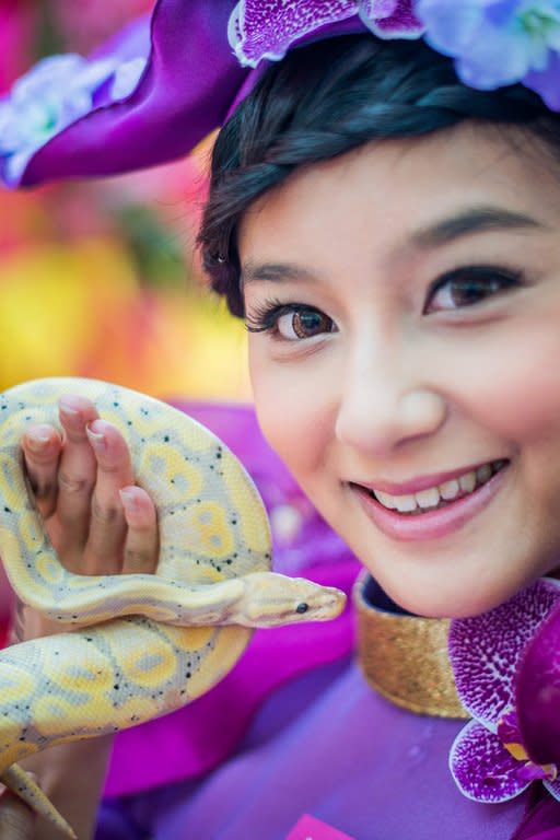 A model poses with a snake during an event to promote responsible snake breeding and pet ownership, in Kong Kong, on January 10, 2013. The Chinese new year, often referred to as the 'Lunar New Year', will mark the year of the snake on February 10