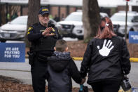 Sgt Jamie Huling of the Newport News Police Department greets students as they return to Richneck Elementary in Newport News, Va., on Monday, Jan. 30, 2023. The elementary school where a 6-year-old boy shot his teacher reopened Monday with stepped-up security and a new administrator, as nervous parents and students expressed optimism about a return to the classroom. (Billy Schuerman/The Virginian-Pilot via AP)