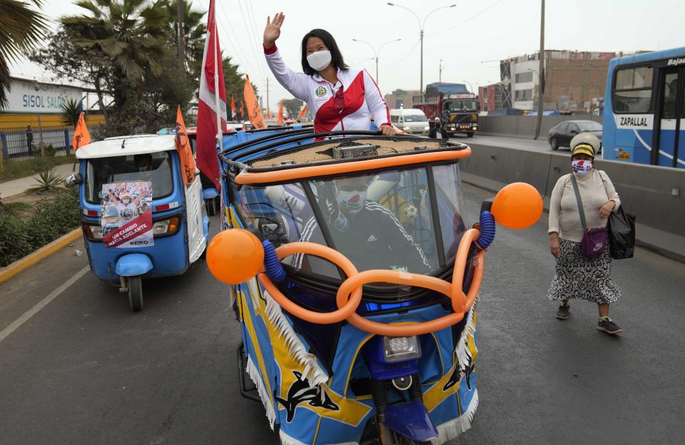 Presidential candidate Keiko Fujimori, of the Popular Force party, waves from the back of a moto-taxi during a campaign rally in the Puente Piedra neighborhood, on the outskirts of Lima, Peru, Tuesday, June 1, 2021. Fujimori, one of Peru's most established political figures and the daughter of former president Alberto Fujimori, will face rival candidate Pedro Castillo in the June 6 presidential run-off election. (AP Photo/Martin Mejia)