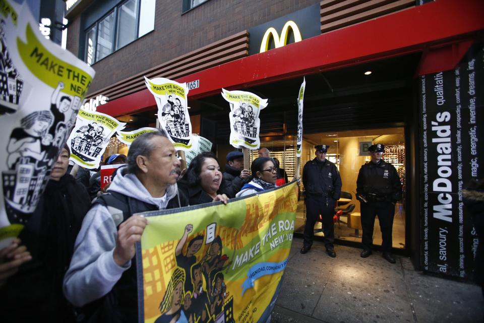 New York Police Department officers stand guard at the entrance of McDonalds restaurant while fast food workers attend a protest against McDonald's in New York, December 5, 2013. (REUTERS/Eduardo Munoz)