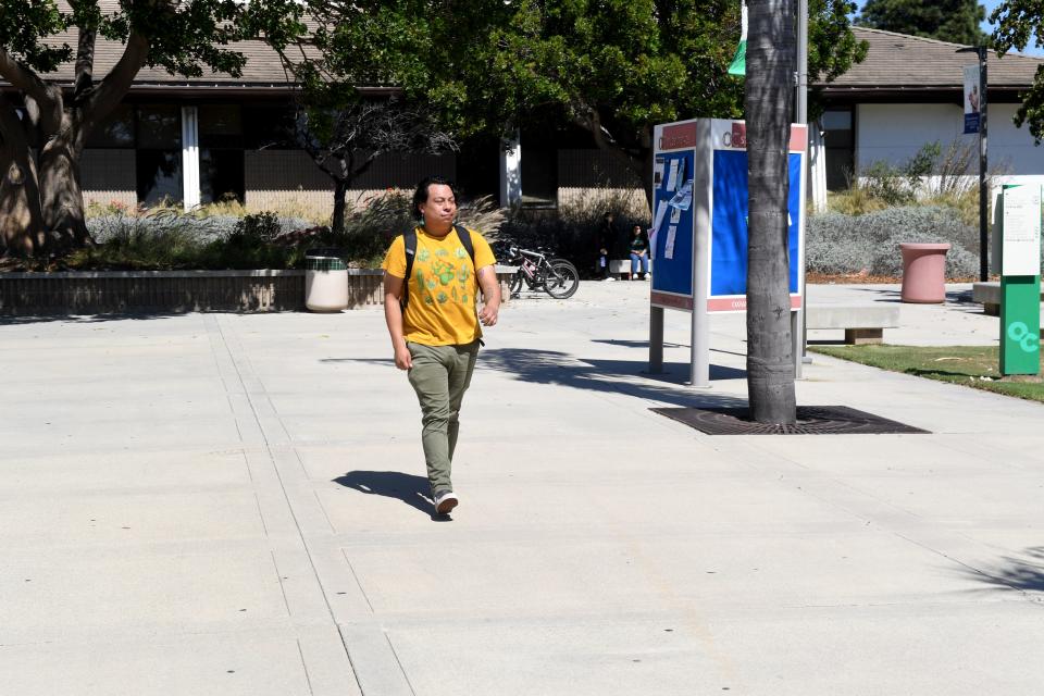 Sergio Solis, of Oxnard, walks through the south quad at Oxnard College. He is part of a wave of students returning to college after the pandemic.