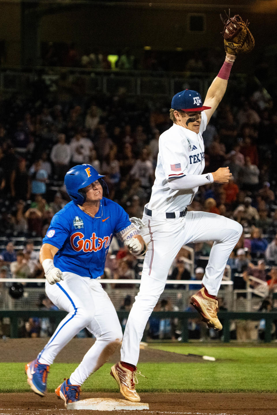 Jun 15, 2024; Omaha, NE, USA; Texas A&M Aggies first baseman Ted Burton (27) gets out Florida Gators third baseman Dale Thomas (1) during the eighth inning at Charles Schwab Field Omaha. Mandatory Credit: Dylan Widger-USA TODAY Sports