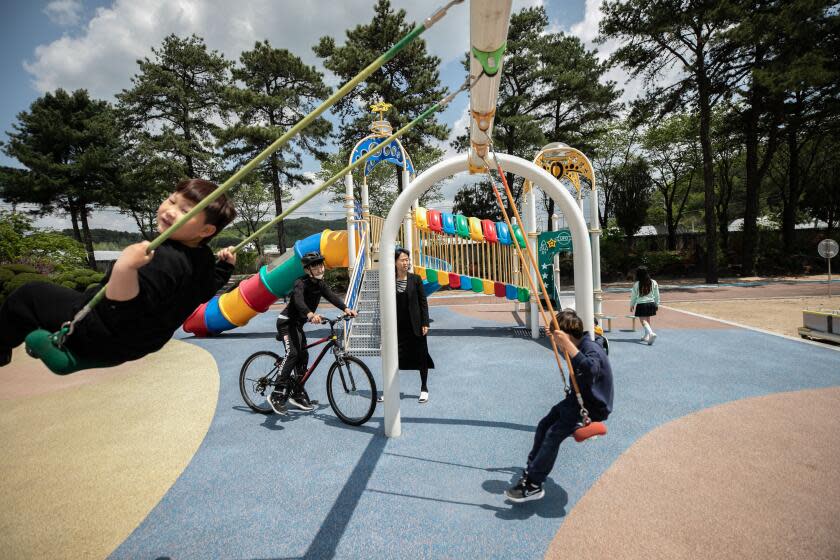 Lee Eun-sook, center, the principal at Dochang Elementary, watches children play in the playground. The decline of South Korea' rural towns and their schools began with the country's rapid industrialization in the 1960s and 1970s, when farming and fishing villages saw a mass exodus of its young workforces to cities like Seoul. From 1982, education authorities responded to the fall in rural populations by shutting down around 5,000 elementary schools, which had become too small and too costly to maintain.