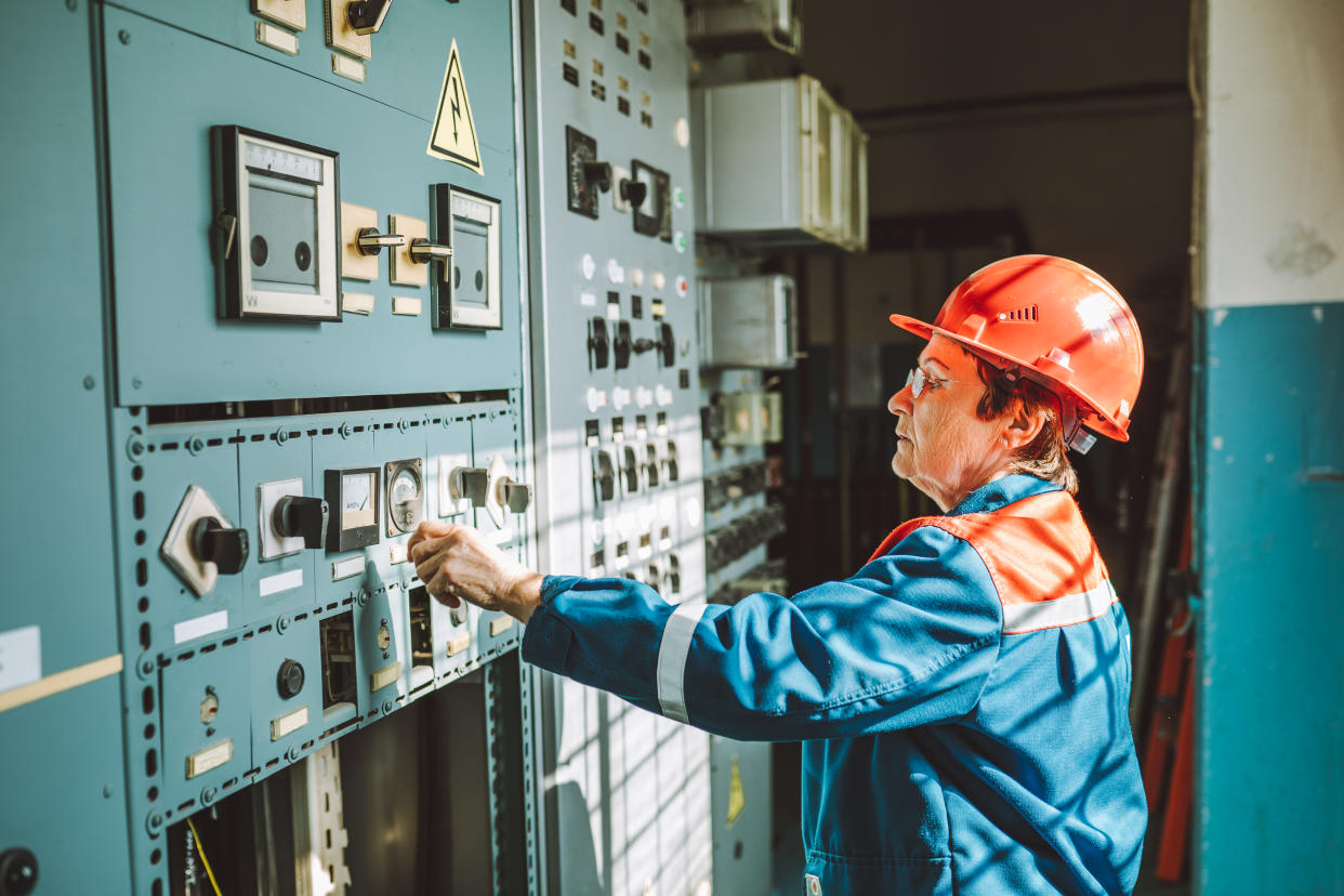 A senior worker adjusts equipment at an electrical dispatching station