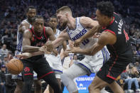 Toronto Raptors forward O.G. Anunoby, left, and Scottie Barnes battle for the ball with Sacramento Kings forward Domantas Sabonis during the first quarter of an NBA basketball game in Sacramento, Calif., Wednesday, Jan. 25, 2023. (AP Photo/Randall Benton)