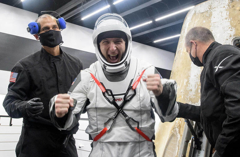 Commander Michael Hopkins pumps his fists with excitement after climbing out of the SpaceX Crew Dragon capsule less than an hour after splashing down in the Gulf of Mexico. All four astronauts appeared in good shape and in high spirits as they began re-adjusting to the unfamiliar tug of gravity. / Credit: NASA