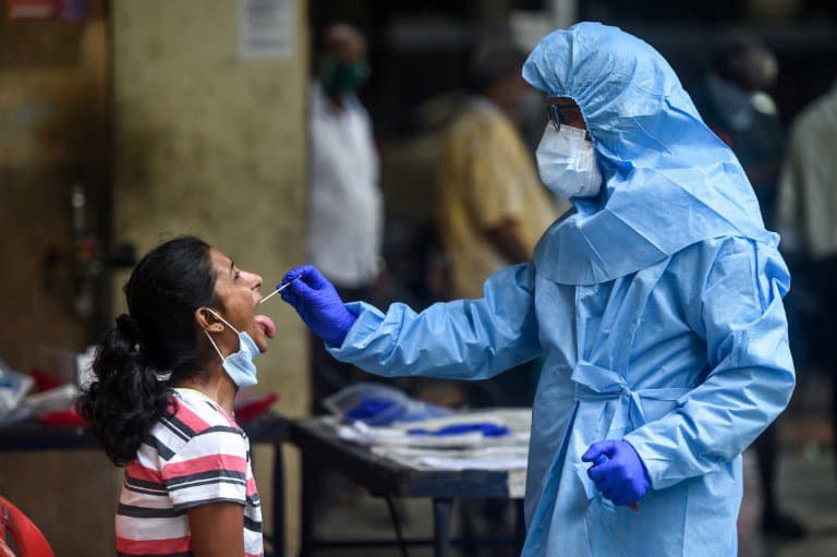 Un soignant effectue un test Covid-19 sur une habitante, à Mumbai (côte ouest de l'Inde), le 16 juillet 2020 - Punit PARANJPE                       © 2019 AFP