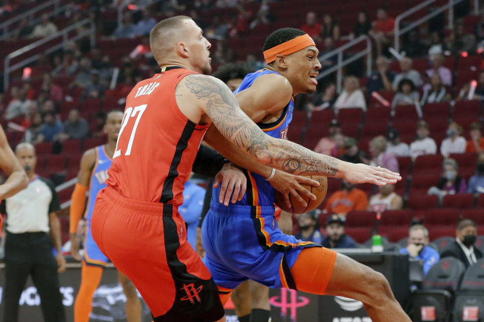 Oklahoma City Thunder forward Darius Bazley, right, drives to the basket in front of Houston Rockets center Daniel Theis (27) during the first half of an NBA basketball game Friday, Oct. 22, 2021, in Houston. (AP Photo/Michael Wyke)