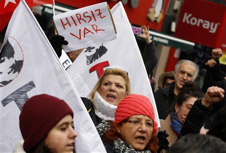A woman holds a sign that reads "There is a thief" as protesters demonstrate against Turkey's ruling Ak Party (AKP) and Prime Minister Tayyip Erdogan in Ankara December 21, 2013. REUTERS/Umit Bektas