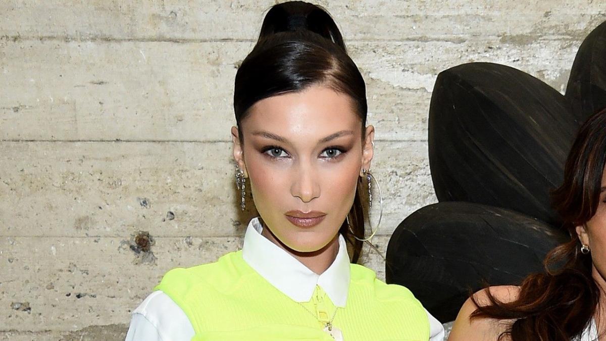 bella hadid rocks neon vest over a short white dress as she